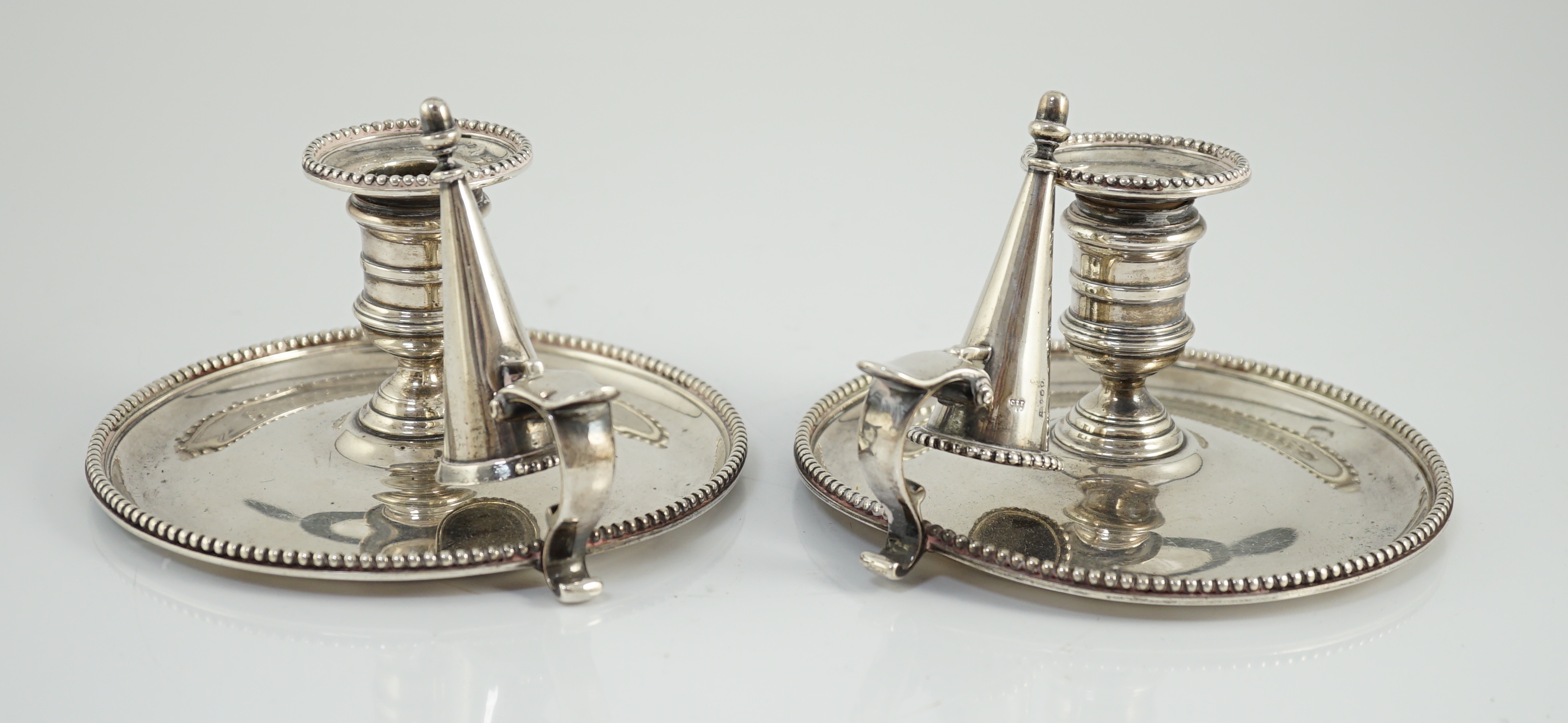 A pair of Victorian silver chambersticks and extinguishers, by Charles Thomas Fox and George Fox